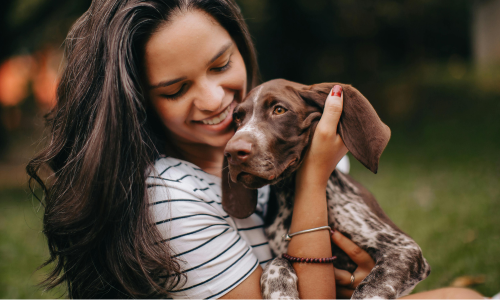 A woman hugging her dog.